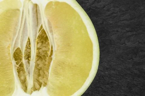 Close-up background surface view of cut pomelo fruit on black stone backgroun Stock Photos
