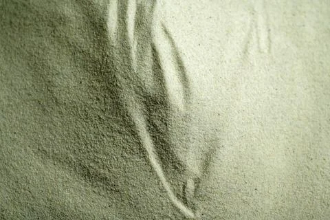 Close-up background texture of fine natural sand with soft wave patterns. S.. Stock Photos
