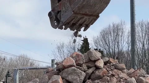 Close up of a backhoe moving rocks to a pile Stock Footage 234218787