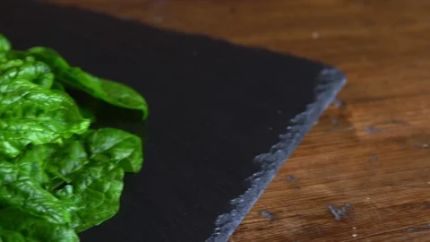 Close-up backlight of freshly picked green spinach leaves placed on a slate plat Vídeos de archivo 126049287