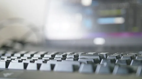 Close up of backlit keyboard with computer screen running video editing software Vidéo 102179083