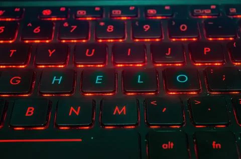 A close up of a backlit keyboard with red lighting, highlighting the keys G.. Foto stock