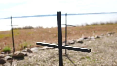 Close up on a backlit simple metal cross in a rural field Stock Footage 166662320