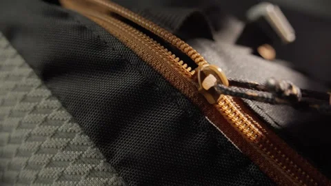 Close-up of a Backpack Zipper with Orange Pull Tab in Use Stock Footage 296158958