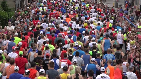 Close up of the backs of people running in a marathon Stock Footage 139976672