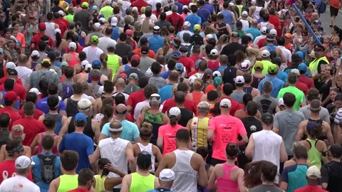 Close up of the backs of runners in a marathon Stock Footage 139976860