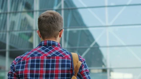 Close up. Backview of a happy young man with a backpack walking. Blurred Stock Footage 81047845