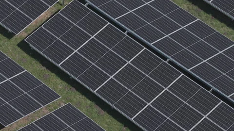 Close-up backward drone flight over large double solar panels in a green ph.. Vídeo Stock 332704173