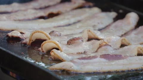 Close up of bacon on griddle cooking outside Stock Footage 287349058