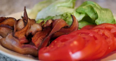 Close-up of bacon, lettuce, tomatoes on white plate in kitchen. Stock Footage 138333034