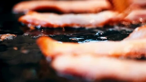 Close-up of bacon slices in frying pan. Bacon sizzling in frying pan, close up. 스톡 동영상 334642350
