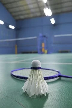 Close-up of a badminton shuttlecock resting on the strings of a racket Stock Photos