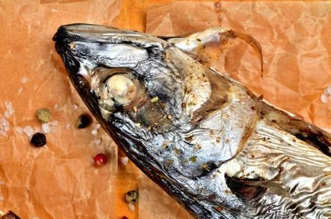 Close-up of baked head of mackerel with garlic, pepper and coarse salt on baking Stock Photos