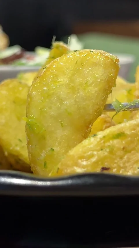 Close-up baked potato until crisp, fork with potato wedges Video stock 347254948