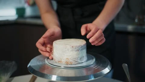Close-up of baker applying white fondant to cake Stock-Footage 336045902