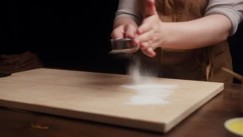 Close up of baker dusting a wooden board with flour using a flour sifter. Fine Vídeos de archivo 340019277