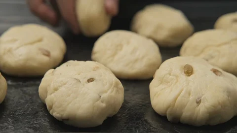 Close-up of baker hands making buns. Cook put dough for buns on baking pan. Video stock 128711811