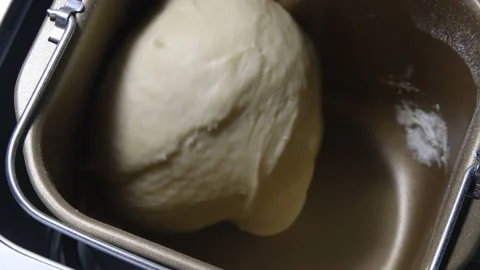 Close-up of a baker kneading dough with Bread Maker machine Stock Footage 138813622