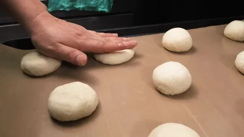 Close-up of a baker or cook's hand pressing down on raw pizza or bread dough bal Stock Footage 331632591