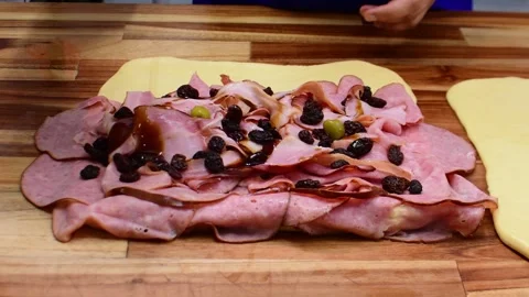 Close up baker pouring dark syrup over traditional pan de jamon doughs Stock Footage 332621985