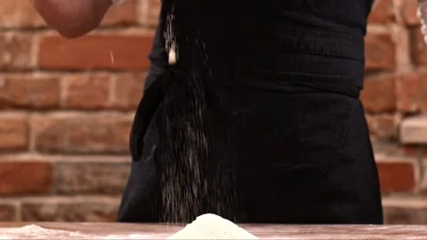 Close-up of baker pours flour in kitchen. Action. Baker sprinkles pinch of flour Stock Footage 151119748
