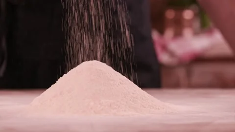 Close-up of baker pours flour in kitchen. Action. Baker sprinkles pinch of flour Vídeos de archivo 151119897