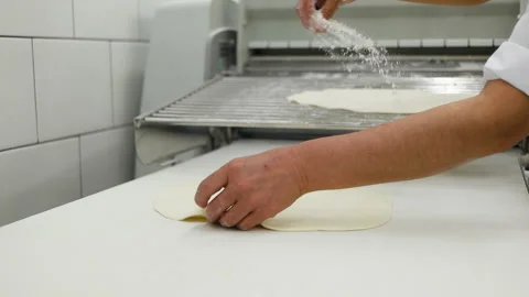 Close-up of baker pours flour in kitchen. Dust the pizza base with flour for the 스톡 동영상 167021374
