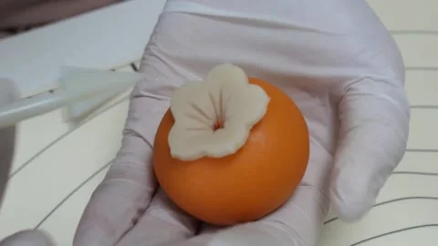 Close-Up of Baker Shaping Fondant Persimmon with Cake Decorating Tool Stock Footage 345293564
