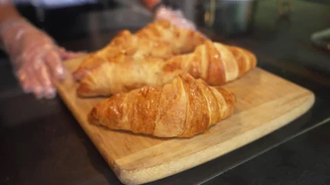 Close-Up of Baker Sliding Fresh Croissants at Cozy Coffee and Pastry Shop Stock-Footage 346249293