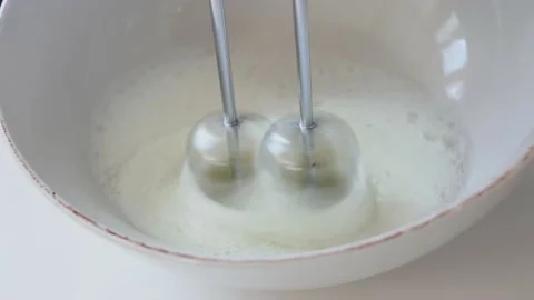 Close up baker whisks fresh raw natural egg in the glass bowl. Process preparing Stock Footage 147549491