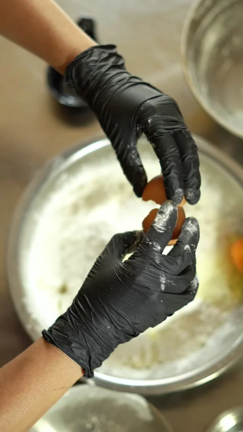 Close-Up of Baker's Hands Cracking an Egg into a Delicious Recipe Mix Stock Footage 285642030