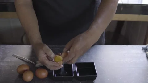 Close up a Baker's hands separating the yolks and whites of an egg Stock Footage 272498975