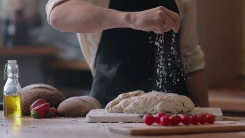 Close up of bakery chef applying flour on dough, man kneading dough, making Stock Footage 261435602