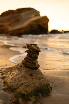 Close-up of a balanced stack of beach stones on wet sand Foto stock
