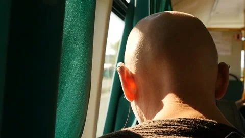 Close-up of a bald man. Turned back to the camera. Slow motion. Bright sunny day Stock Footage 128288857