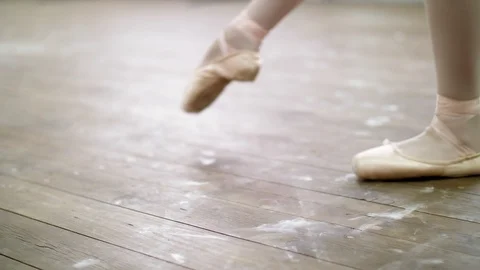 Close up, in ballet class, on an old wooden floor, ballerina performs glissade Stock Footage 89147377