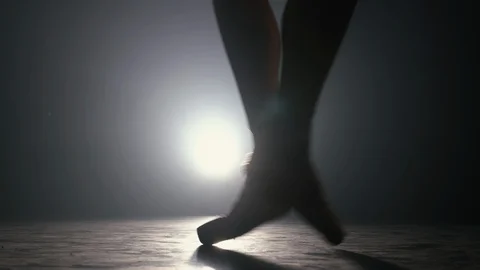 Close up of ballet dancer as she practices exercises on dark stage or studio Stock Footage 127590369