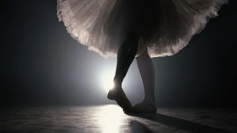 Close up of ballet dancer as she practices exercises on dark stage or studio Stock Footage 127590970