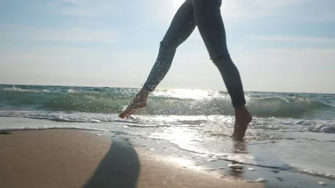 Close up of a ballet dancer's barefoot feet running on sandy wet beach Stock Footage
