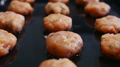 Close-up of balls of minced fish lie on a black metal baking sheet. Stock Footage 146403539
