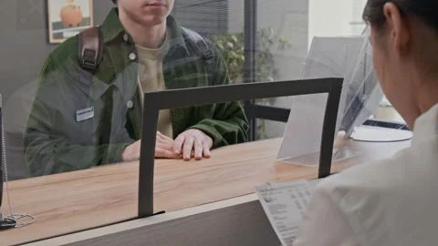 Close up of Bank Teller Accepting Document from Customer in Bank Stock Footage 330970263
