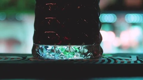 Close up of the bar counter on the color light background with glass of drink Stock Footage 84754540