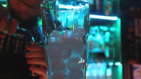 Close up of bar glass and bartender making drinks on bar counter on the green Stock Footage 84759470
