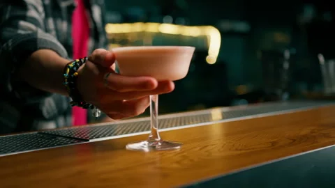 A close-up of a bar guest holding a ready-made tasty bilberry club alcoholic Stock Footage 240450315