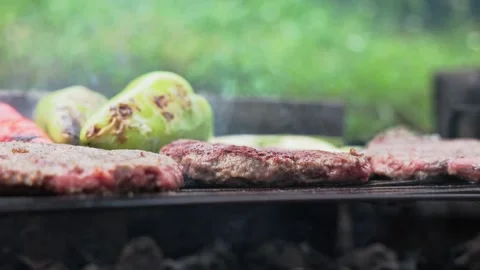 Close up of barbecue, grilling minced red meat burger patties and veggies Stock Footage 264479176