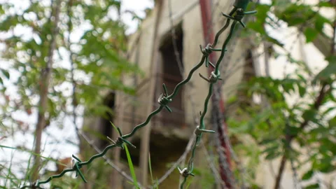 Close-up of barbed-wire, empty neglected building, UN buffer zone Nicosia Stock Footage 237521233