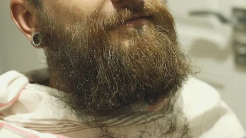 Close up barber is cutting a beard man. Haircut of a beard. Barbershop Stock Footage 79848906