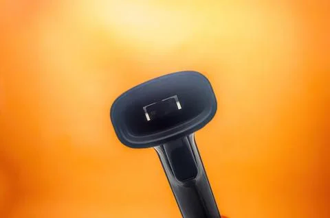 Close up of a barcode scanner against a vibrant orange background. The imag.. 库存照片