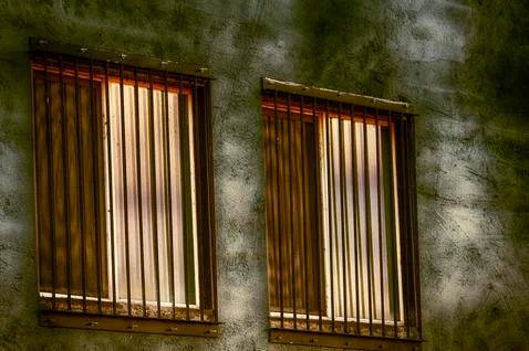 Close up of barded windows reflecting sunlight Stock Photos