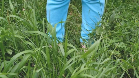Close-up - the bare feet of a small child in blue leggings Stock Footage 100269891